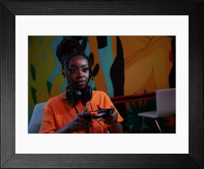 Framed Print : Focused gamer girl with headset playing video games Framed Print : Focused gamer girl with headset playing video games