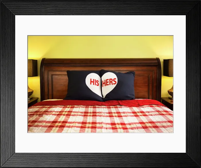 Framed Print : Detail shot of decorative His and Hers Pillows on dark wooden sleigh bed with red and white plaid comforter in master bedroom of home Framed Print : Detail shot of decorative His and Hers Pillows on dark wooden sleigh bed with red and white plaid comforter in master bedroom of home