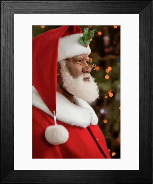 Framed Print : 2207875. An African American man dressed as Santa Claus sitting in front Framed Print : 2207875. An African American man dressed as Santa Claus sitting in front