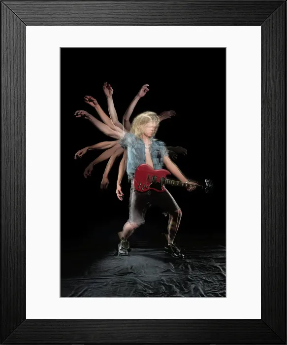 Framed Print : Stroboscopic photos of young man playing electric guitar on black background