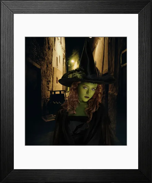 Framed Print : Young girl dressed as witch standing in front dark alley Framed Print : Young girl dressed as witch standing in front dark alley