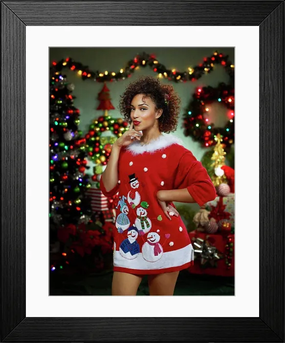 Framed Print : Portrait of an African American woman in ugly Christmas sweater looking at camera with a flirtatious expression Framed Print : Portrait of an African American woman in ugly Christmas sweater looking at camera with a flirtatious expression