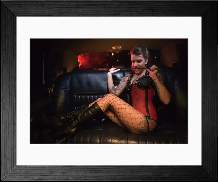 Framed Print : BLD069954. Dominatrix biting riding crop in limousine Framed Print : BLD069954. Dominatrix biting riding crop in limousine