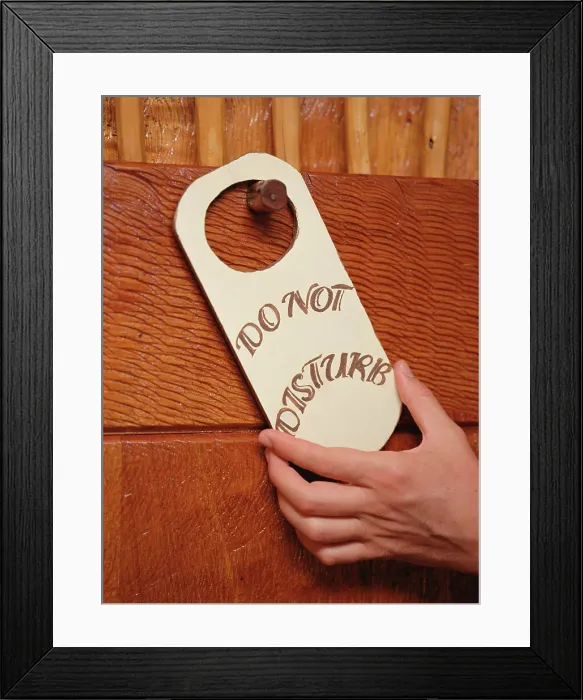 Framed Print : BLD028306. Hand putting Do Not Disturb sign on doorknob