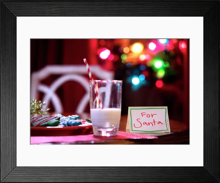 Framed Print : Cookies for santa on table with christmas tree in the background