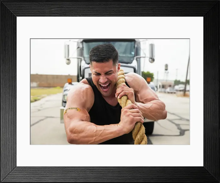 Framed Print : Muscular Hispanic man wearing tank top with Strong tattoo on his bicep, Straining to pull semi truck with large tow rope Framed Print : Muscular Hispanic man wearing tank top with Strong tattoo on his bicep, Straining to pull semi truck with large tow rope