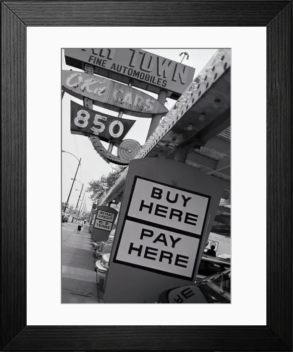 Framed Print : Buy Here Pay Here sign outside of a car dealership