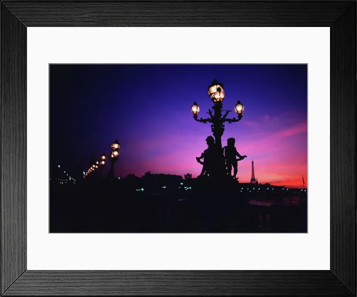 Framed Print : Lampposts lit up at night with tower in the background Framed Print : Lampposts lit up at night with tower in the background