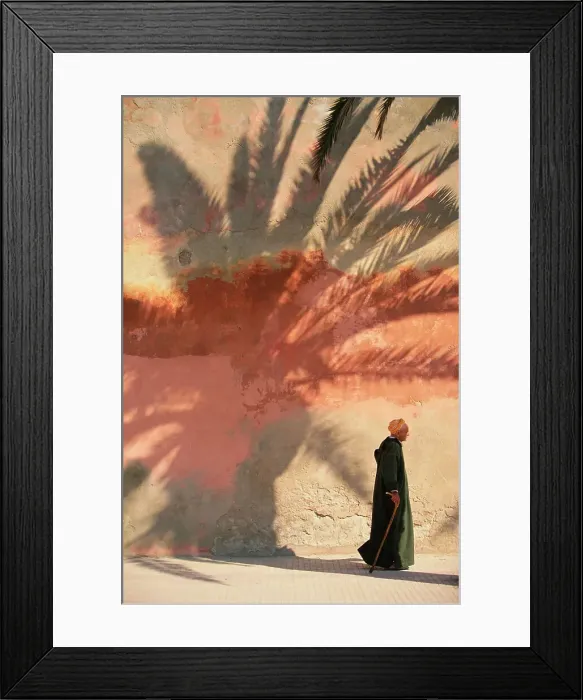 Framed Print : Man in robes walking by wall with palm shadow Framed Print : Man in robes walking by wall with palm shadow