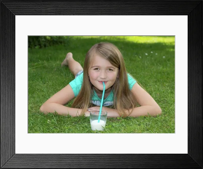 Framed Print : Girl lying on meadow drinking milk with drinking straw Framed Print : Girl lying on meadow drinking milk with drinking straw