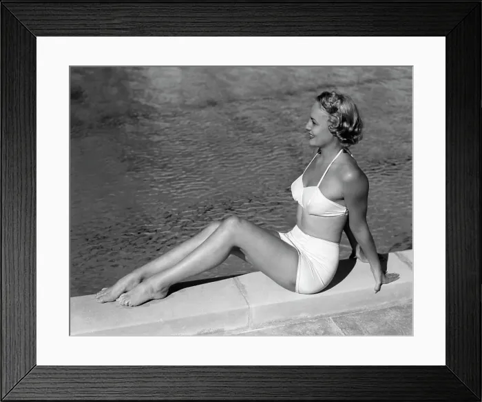 Framed Print : 1940S Blond Woman Sitting By Side Of Swimming Pool Wearing White Two Piece Bathing Suit Framed Print : 1940S Blond Woman Sitting By Side Of Swimming Pool Wearing White Two Piece Bathing Suit