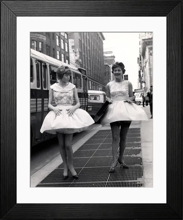 Framed Print : Two young women in short dresses and stockings walking over sidewalk vent Framed Print : Two young women in short dresses and stockings walking over sidewalk vent
