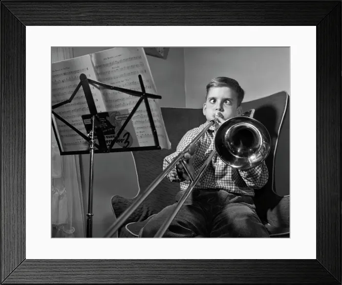 Framed Print : 1950s FUNNY CROSS-EYED BOY PLAYING SLIDE TROMBONE