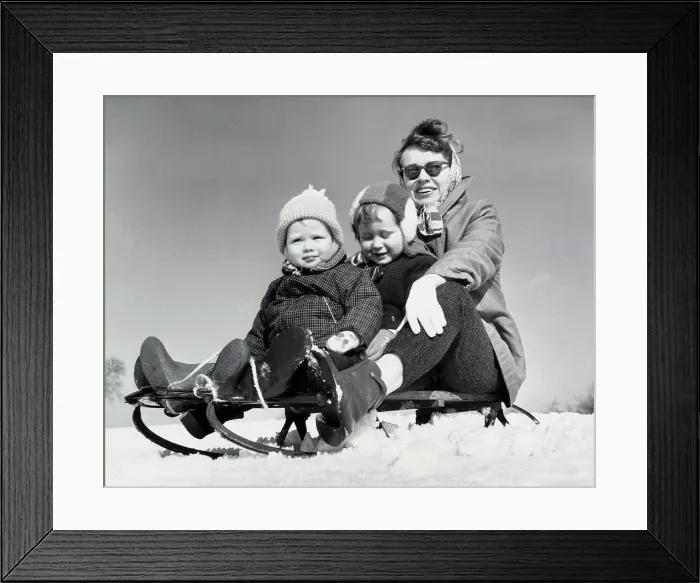 Framed Print : Close-up of a mother with her two children sitting on a sled