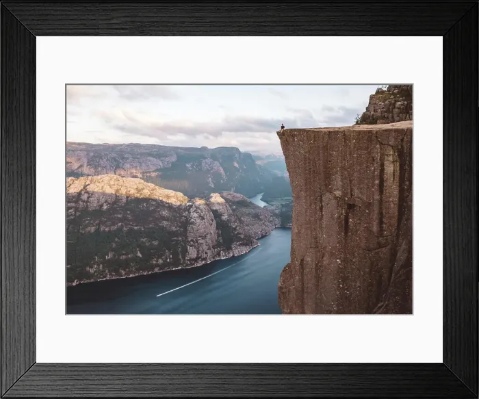 Framed Print : Man sitting at edge of cliff at Preikestolen, Norway Framed Print : Man sitting at edge of cliff at Preikestolen, Norway
