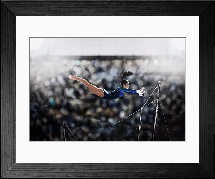 Framed Print : A female gymnast, a young woman performing on the parallel bars, in mid flight reaching towards the top bar Framed Print : A female gymnast, a young woman performing on the parallel bars, in mid flight reaching towards the top bar