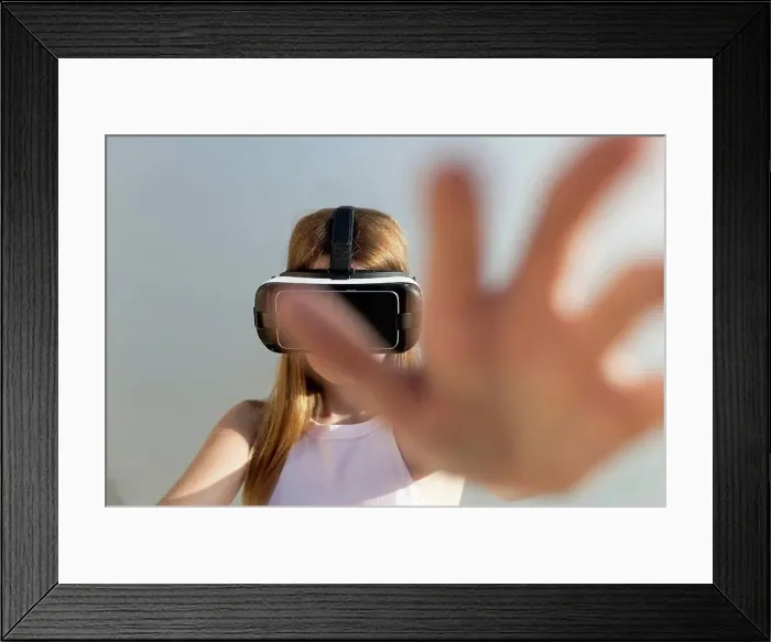 Framed Print : Young woman using Vr googles, reaching with her hand Framed Print : Young woman using Vr googles, reaching with her hand