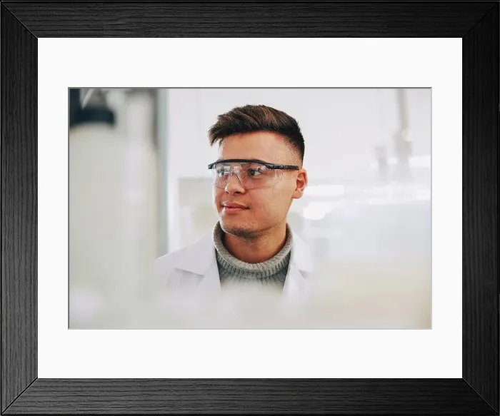 Framed Print : Confident young chemistry student wearing eyewear looking away in laboratory Framed Print : Confident young chemistry student wearing eyewear looking away in laboratory