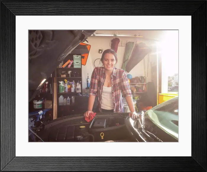 Framed Print : Woman fixing car in garage Framed Print : Woman fixing car in garage