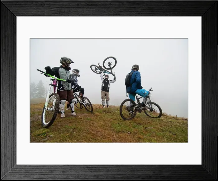 Framed Print : Friends looking at man picking up bicycle on mountain Framed Print : Friends looking at man picking up bicycle on mountain