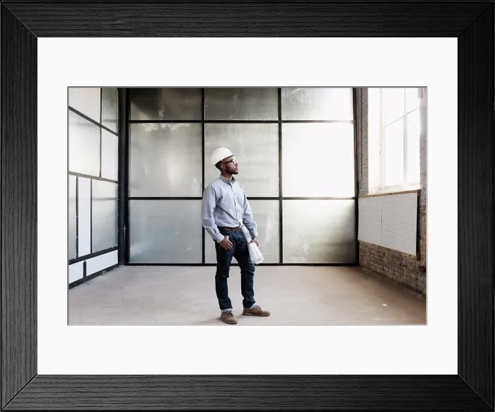 Framed Print : Portrait of young male interior designer in empty room Framed Print : Portrait of young male interior designer in empty room