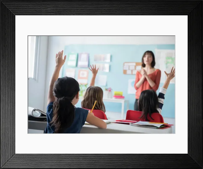Framed Print : Girls raising hand for teacher in classroom Framed Print : Girls raising hand for teacher in classroom