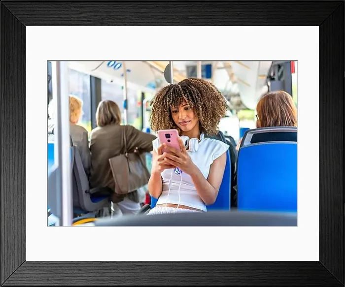 Framed Print : Young beauty latin woman with curly hair and casual clothes using phone distracted sitting on public bus Framed Print : Young beauty latin woman with curly hair and casual clothes using phone distracted sitting on public bus
