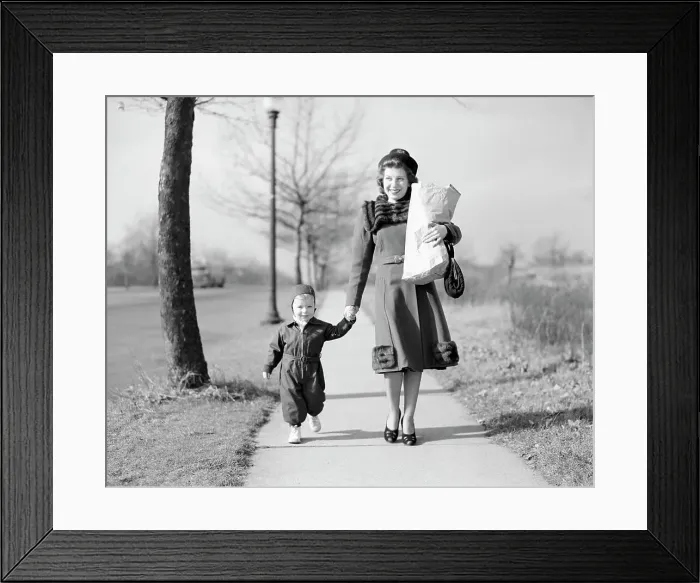 Framed Print : Mother walking with baby daughter along footpath, carrying shopping