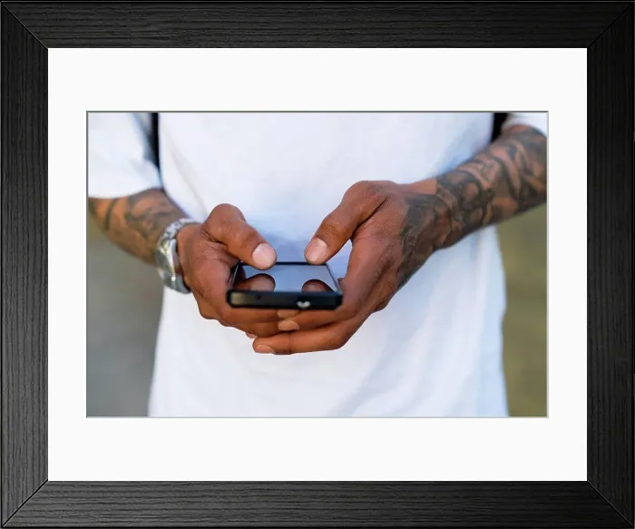 Framed Print : Hands of tattooed man using smartphone, close-up Framed Print : Hands of tattooed man using smartphone, close-up