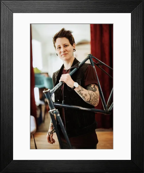 Framed Print : Portrait of pierced and tattooed woman with bicycle frame on her shoulder Framed Print : Portrait of pierced and tattooed woman with bicycle frame on her shoulder