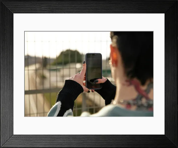 Framed Print : Girl taking photo through her smartphone
