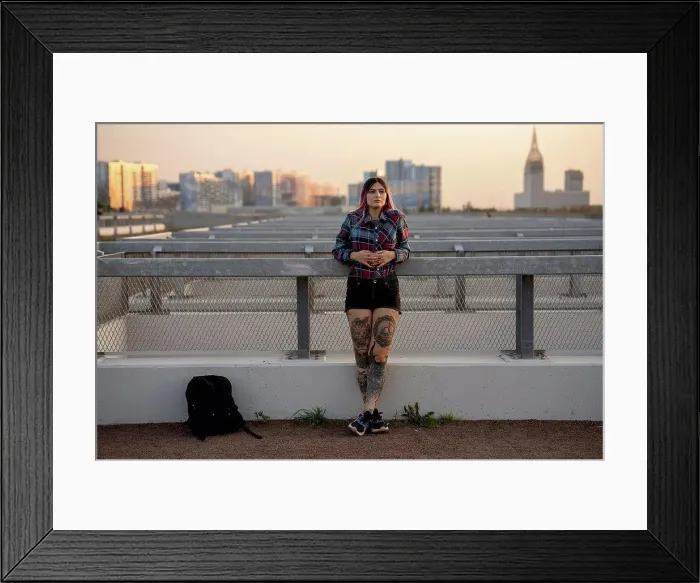 Framed Print : Fashionable woman day dreaming while leaning on railing at rooftop during sunset Framed Print : Fashionable woman day dreaming while leaning on railing at rooftop during sunset