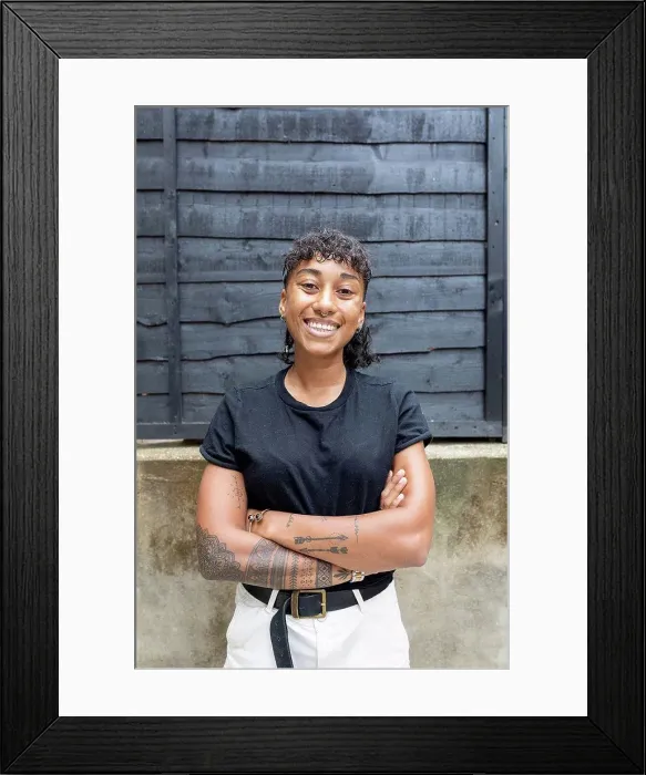 Framed Print : Woman smiling while standing with arms crossed against wall at back yard Framed Print : Woman smiling while standing with arms crossed against wall at back yard