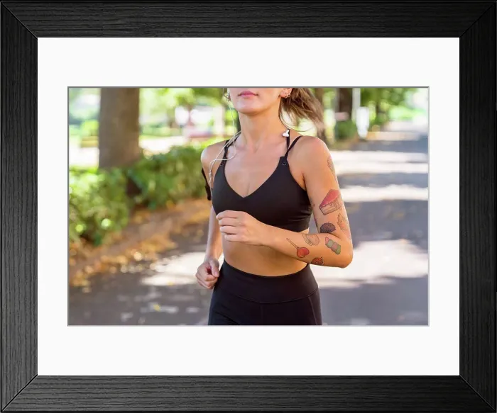 Framed Print : Close-up of young woman running on a tree-lined road Framed Print : Close-up of young woman running on a tree-lined road