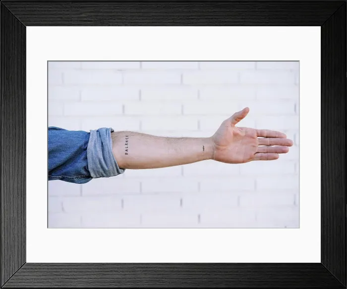 Framed Print : Man's hand with tattoo against brick wall
