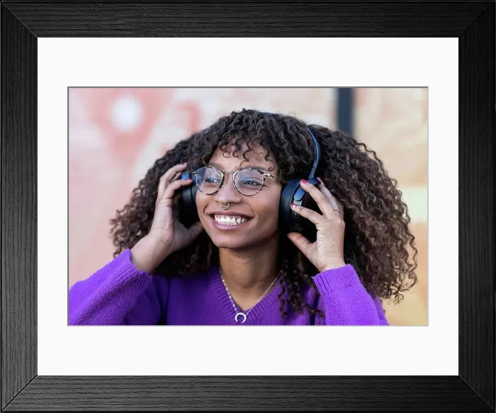 Framed Print : Smiling woman enjoying music through headphones Framed Print : Smiling woman enjoying music through headphones