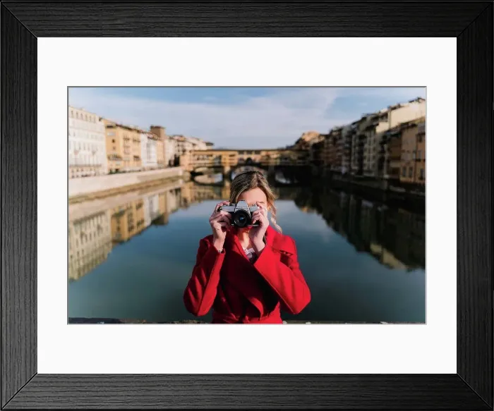 Framed Print : Young woman taking a picture on a bridge above river Arno, Florence, Italy Framed Print : Young woman taking a picture on a bridge above river Arno, Florence, Italy