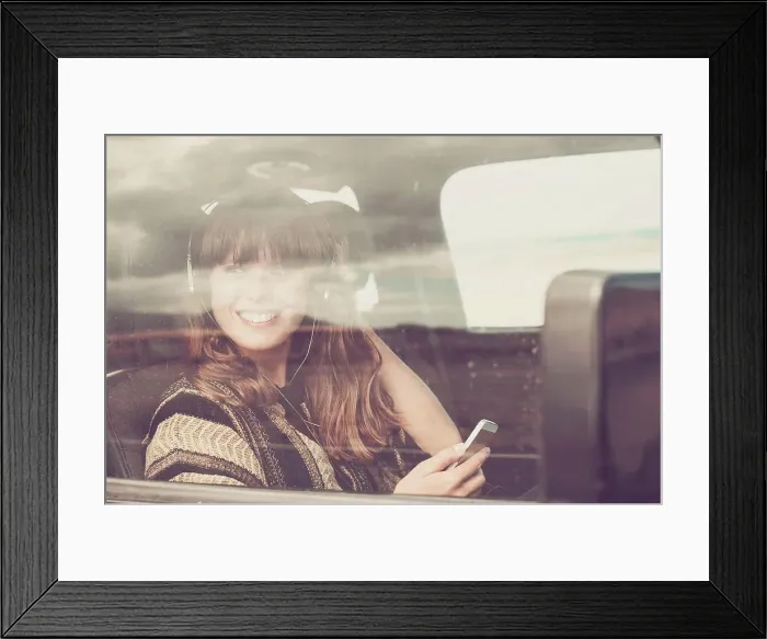Framed Print : Young woman travelling in car listening music Framed Print : Young woman travelling in car listening music