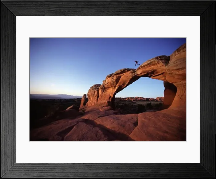 Framed Print : Side profile of a man leaping on a natural arch, Arches National Park, Utah, USA Framed Print : Side profile of a man leaping on a natural arch, Arches National Park, Utah, USA