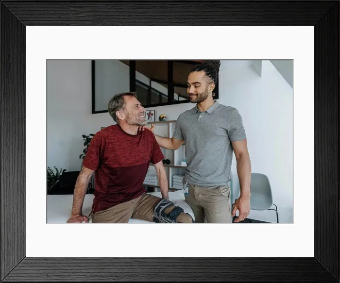 Framed Print : Male physiotherapist with smiling patient in medical practice Framed Print : Male physiotherapist with smiling patient in medical practice