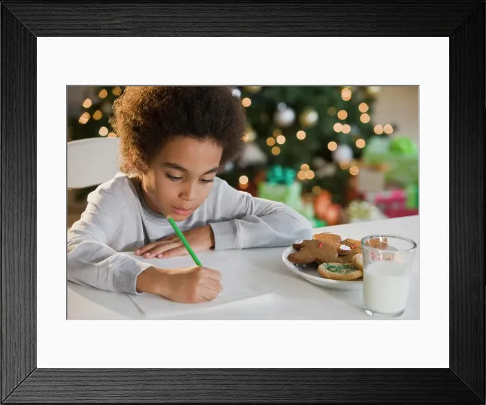 Framed Print : Mixed Race boy writing letter to Santa Claus Framed Print : Mixed Race boy writing letter to Santa Claus