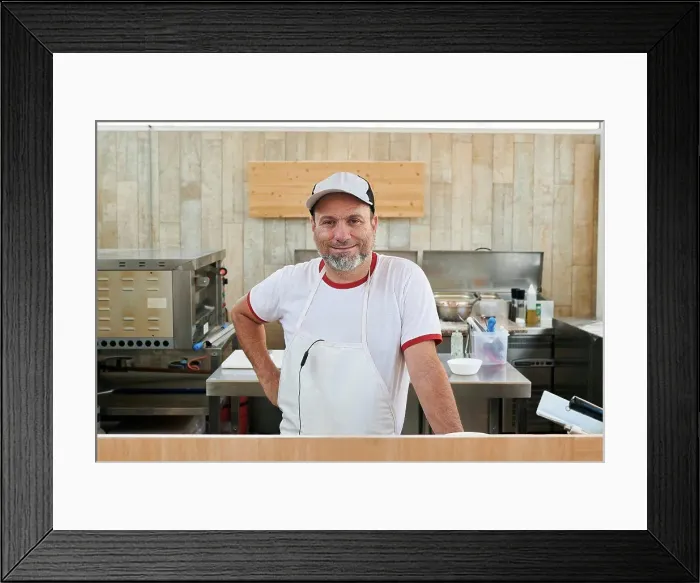 Framed Print : Small restaurant owner looks at the camera Framed Print : Small restaurant owner looks at the camera