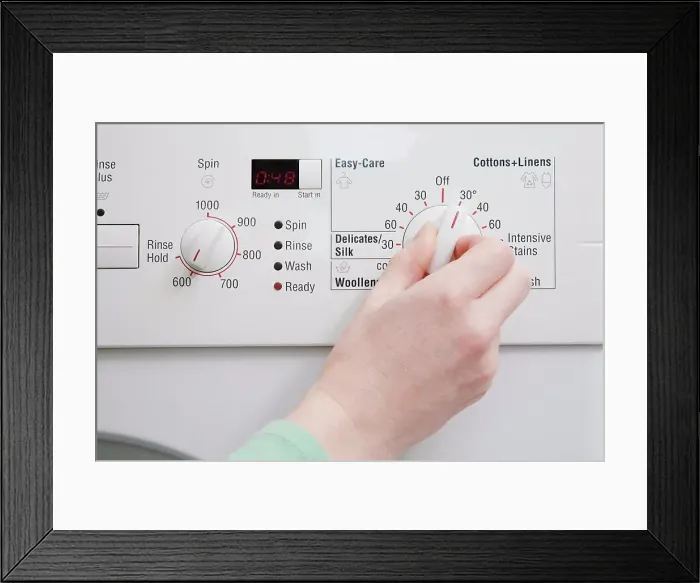Framed Print : Person turning dial on washing machine Framed Print : Person turning dial on washing machine