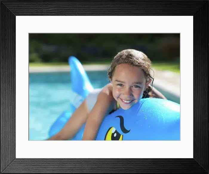 Framed Print : Girl riding inflatable toy in swimming pool