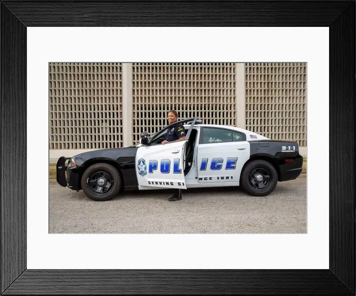 Framed Print : Policewoman standing in door of Police car looking towards camera smiling Framed Print : Policewoman standing in door of Police car looking towards camera smiling
