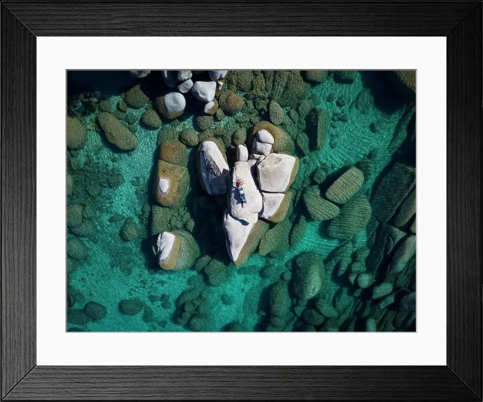 Framed Print : aerial view female laying on rock in lake tahoe