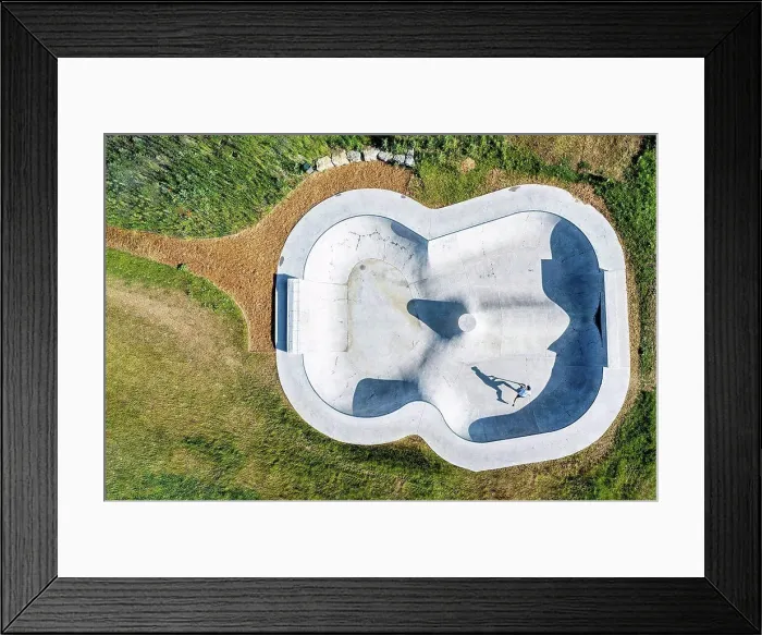 Framed Print : Young man riding push scooter at skateboard park Framed Print : Young man riding push scooter at skateboard park