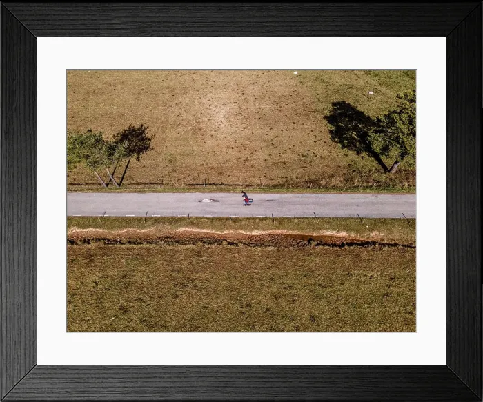 Framed Print : Aerial overhead view of skateboarding man in a mountain road Framed Print : Aerial overhead view of skateboarding man in a mountain road