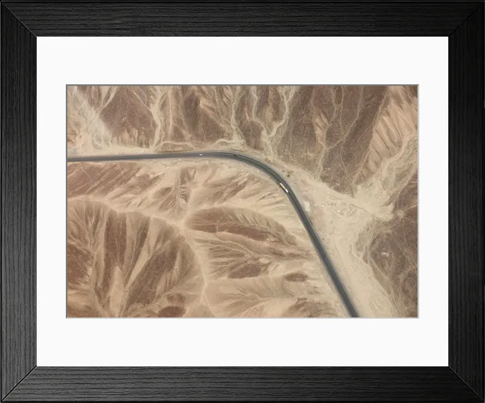 Framed Print : Aerial view of a lonely road snaking through a barren desert landscape Framed Print : Aerial view of a lonely road snaking through a barren desert landscape