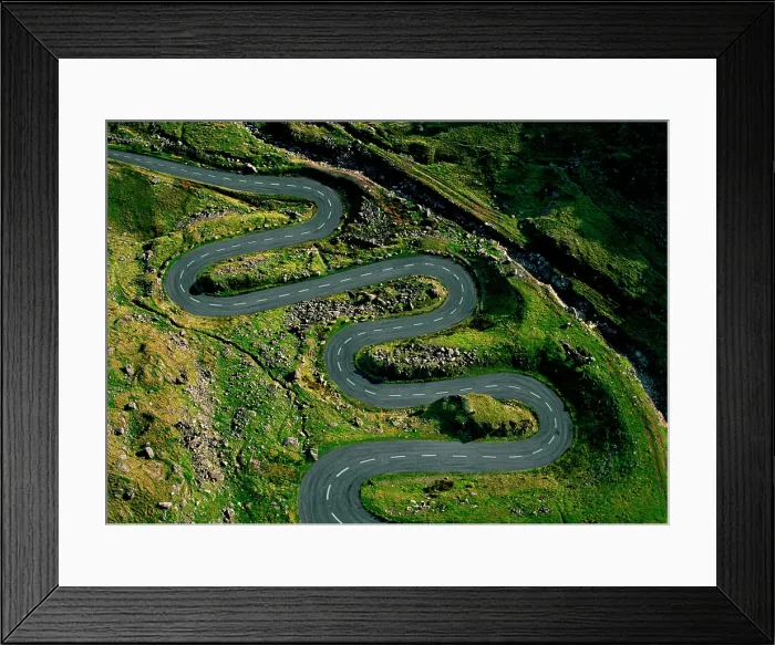 Framed Print : A winding road snakes through a lush green hillside Framed Print : A winding road snakes through a lush green hillside